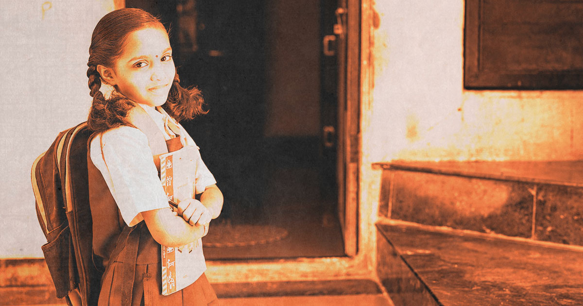 Young school girl in front of classroom door